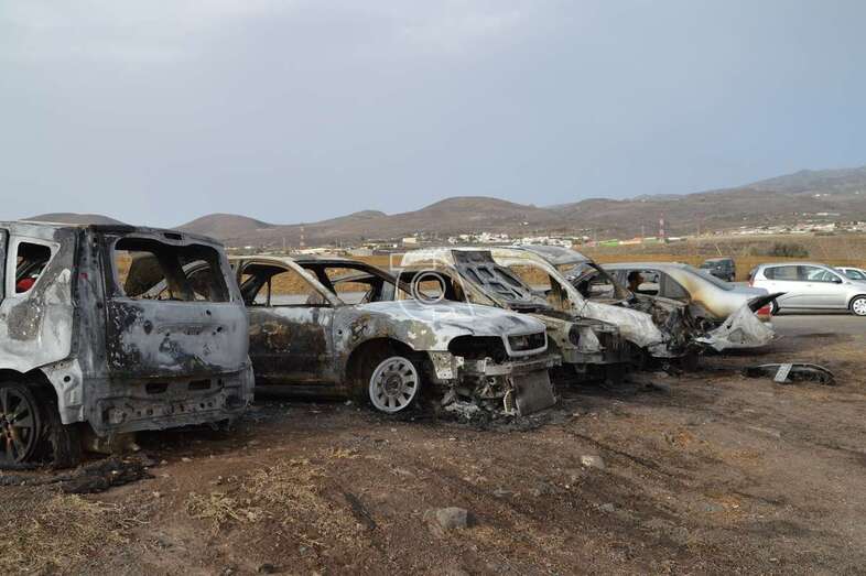 Los restos de los cinco vehículos, en la explanada de tierra donde se originó el incendio/TA.